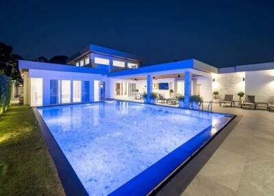 Modern house with illuminated swimming pool at night
