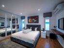 Modern bedroom with bed, mirrored closets, and artwork