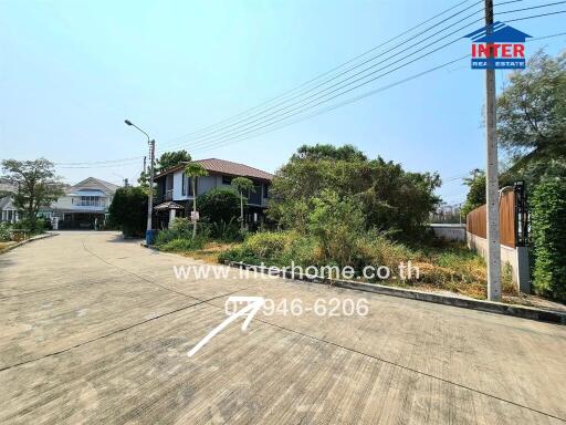 Street view of a residential area including houses and greenery