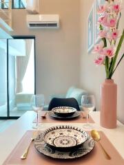 Modern dining area with set table and floral decor