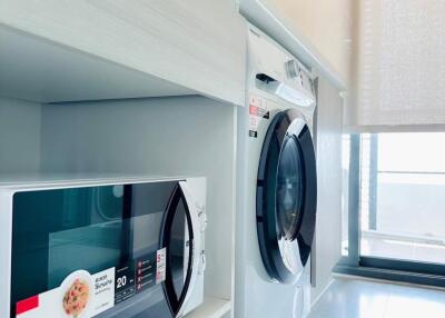 Modern laundry room with washing machine and microwave