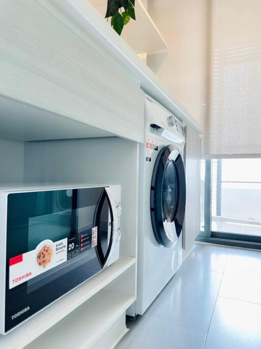 Modern laundry room with washing machine and microwave