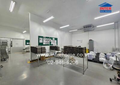 Interior of a commercial space with tables, boxes, and fluorescent lighting