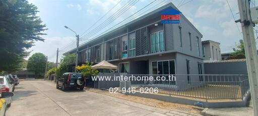 Two-story modern residential building with a fenced yard