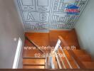 Interior view of a wooden staircase with artistic ceiling design