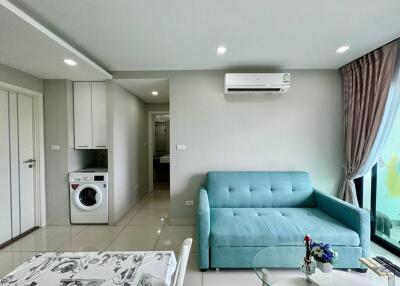 Bright living room with a blue sofa and washing machine