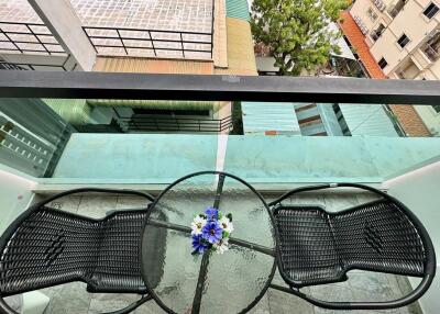 Balcony with glass table and two chairs