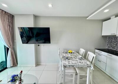 Modern living and dining area with mounted TV and decorative table