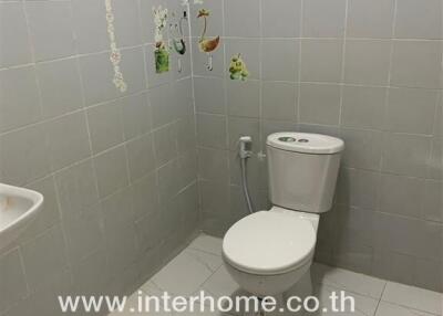 Small clean bathroom with grey tiles and wall art