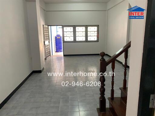 Spacious living room with tiled flooring and natural light