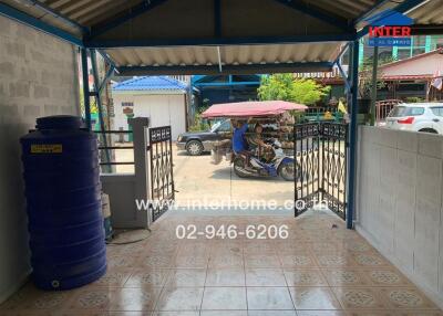 Outdoor entrance area with water tank and tiled floor