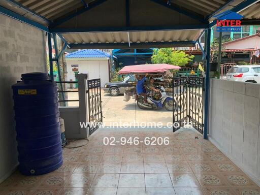 Outdoor entrance area with water tank and tiled floor