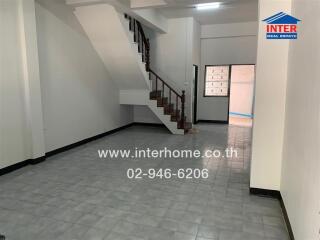 Spacious main living area with staircase in a property listed for sale