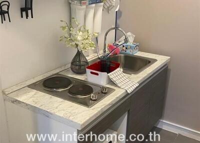 Compact kitchen with countertop stove and sink