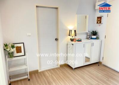 Bright entryway with white door, cabinet, and decorative items