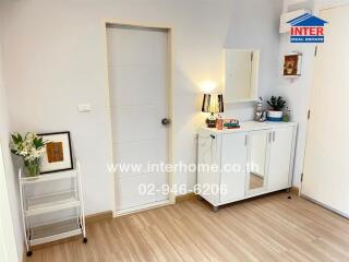 Bright entryway with white door, cabinet, and decorative items