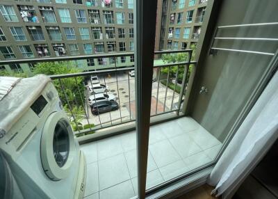 Small balcony area with a washing machine and a view of the residential complex