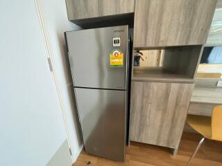 Modern kitchen area with stainless steel refrigerator and wooden cabinetry