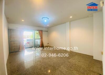 Spacious living area with glossy flooring and a sliding glass door.
