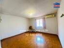 Empty bedroom with wooden flooring, air conditioning unit, and window with pink curtains