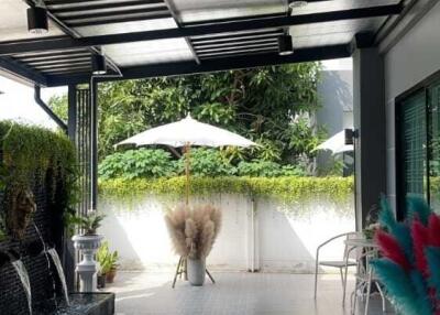 Outdoor terrace with partial roof, seating area, and outdoor decorations