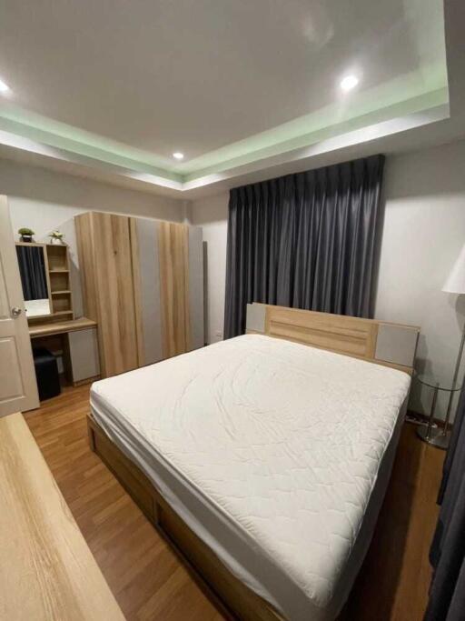 Modern bedroom with furniture including a bed, wardrobe, and desk