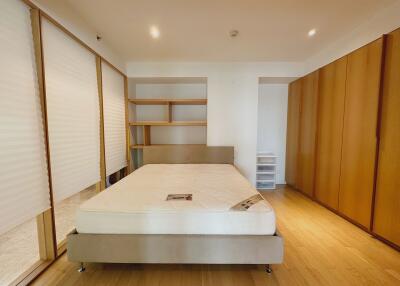 Bedroom with large bed and wooden storage units