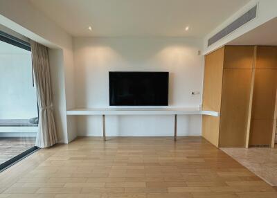 Minimalist living room with wall-mounted TV and wooden flooring