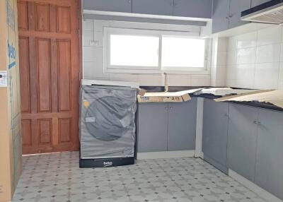 A modern kitchen with ample cabinetry and tiled flooring.