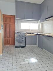 A modern kitchen with ample cabinetry and tiled flooring.