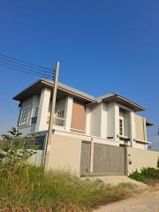 Modern two-story house exterior with a gated entrance