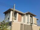 Modern two-story house exterior with a gated entrance