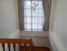 Indoor staircase with a view of large window curtain