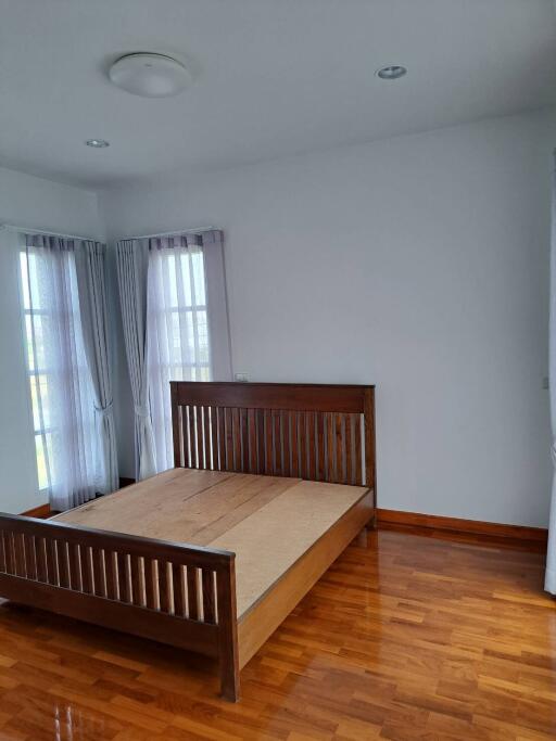 Bedroom with wooden bed frame and hardwood floor