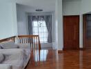 Spacious living room with wooden flooring and large windows