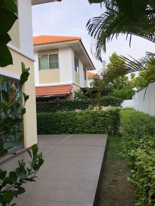 Modern residential building with a garden and tiled pathway