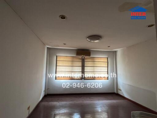 Empty living room with blinds and overhead lights