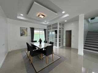 Modern dining area with table, chairs, and decorative ceiling