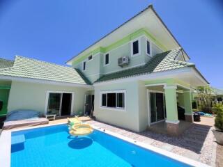 Exterior view of a two-story house with a swimming pool