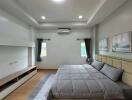 Modern bedroom with double bed, gray bedding, and wall-mounted air conditioner