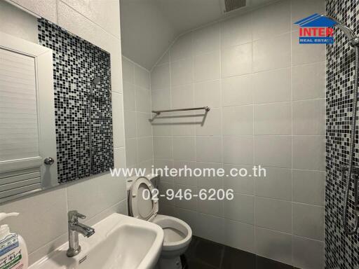 Modern bathroom with white tiles and a washbasin