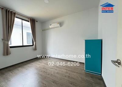 Empty bedroom with wooden floor, large window, air conditioner, and blue wardrobe