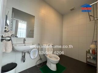 Bathroom with white tiles, sink, toilet, and mirror