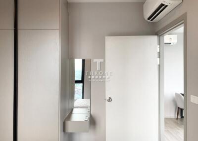 A modern bedroom with a wardrobe and an air conditioning unit.