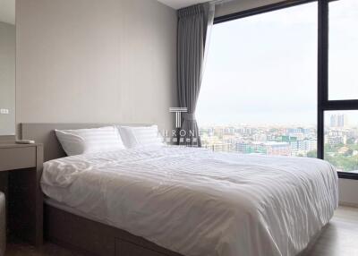 Bedroom with a large window overlooking the city