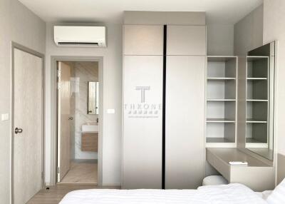 Modern bedroom with wardrobe, vanity, and air conditioning.