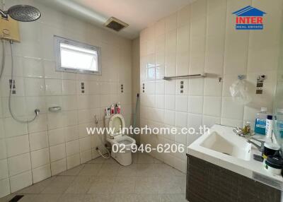 Bathroom with modern fixtures, a toilet, sink, and shower area