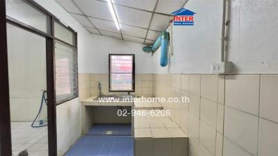 Simple kitchen with tiled walls and basic fixtures