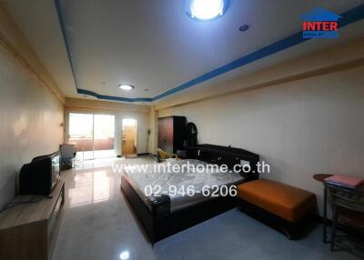 Spacious bedroom with furniture and a television