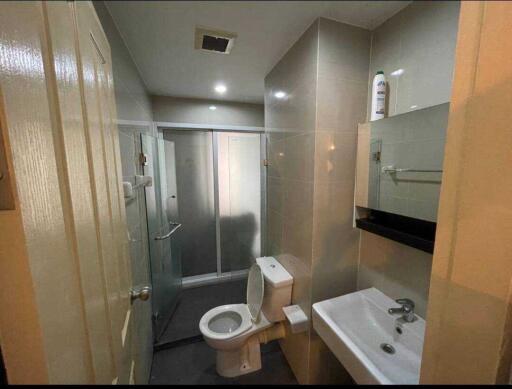 Modern bathroom with glass shower enclosure, toilet, and sink